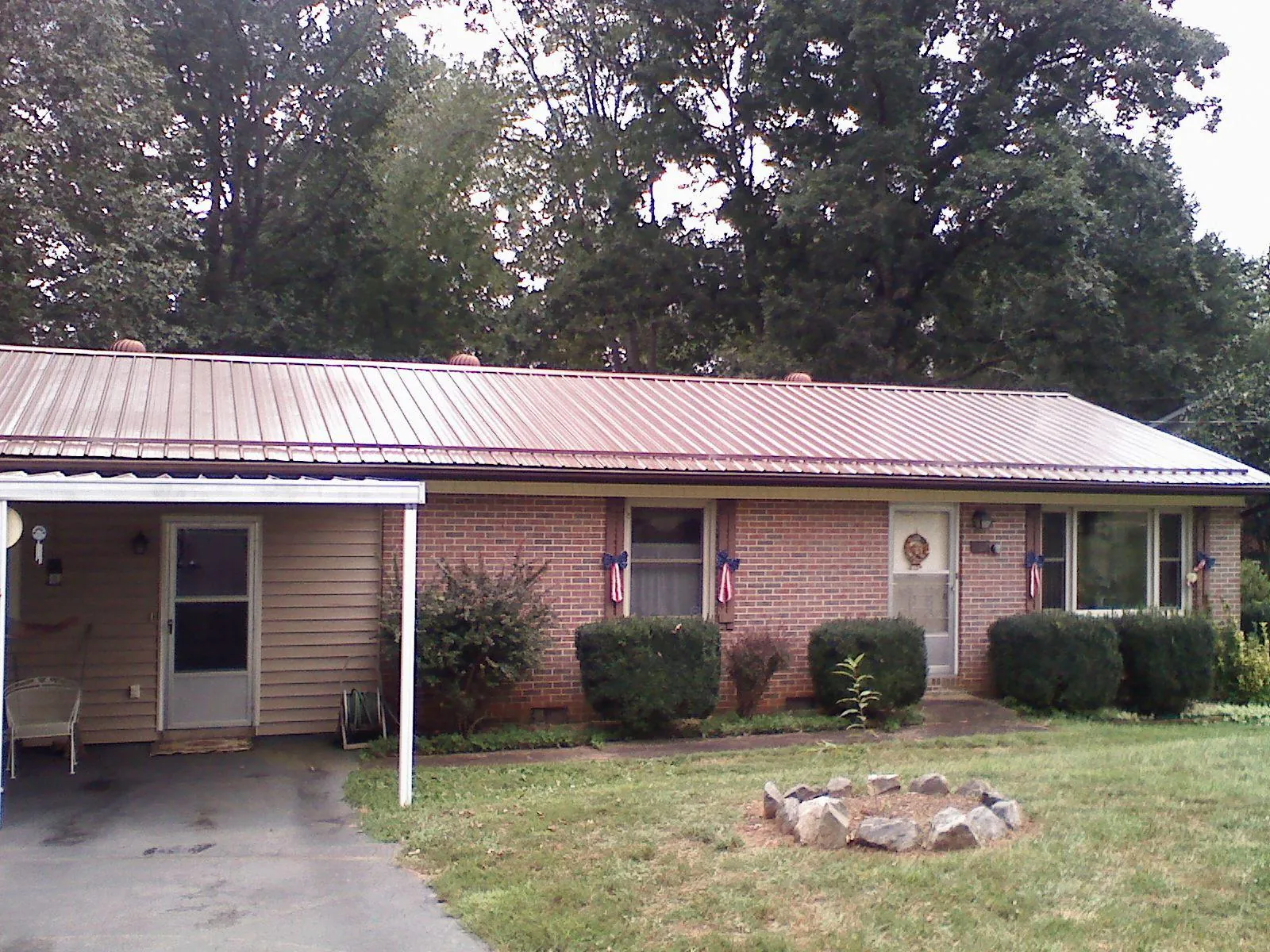 Bronze metal roof and carport on a brick ranch home — Roof Repair work by our crew in Depoe Bay